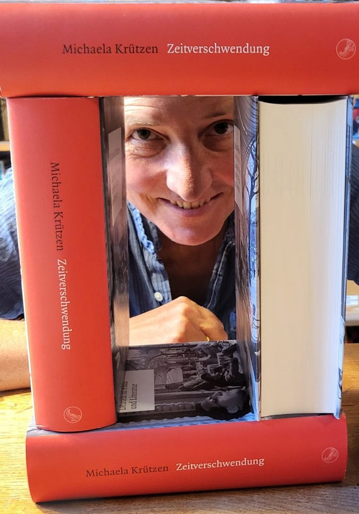 Michaela Krützen schaut durch ihre Bücher.