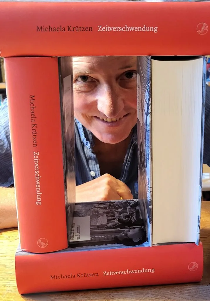 Michaela Krützen schaut durch ihre Bücher.