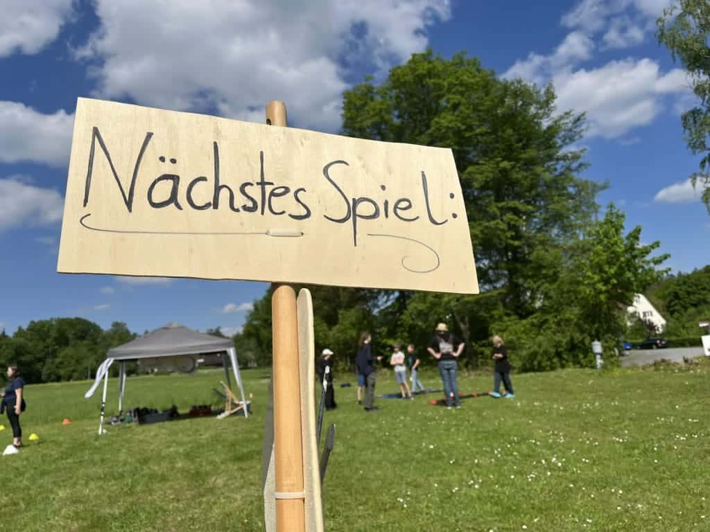 Ein Holzschild, auf dem „Nächstes Spiel“ steht