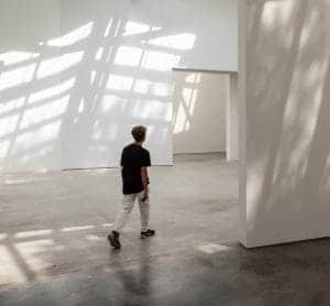 Ein junger Mann durschreitet einen Raum, ein Symbol für die Gestaltung von spirituellen Räumen durch Kommunikation.