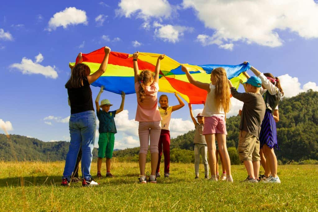 Kinder spielen gemeinsam mit einem bunten Schwungtuch.